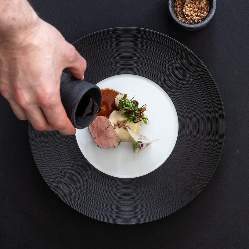 Gericht angerichtet auf schwarzem Teller Gericht angerichtet auf schwarzem Teller