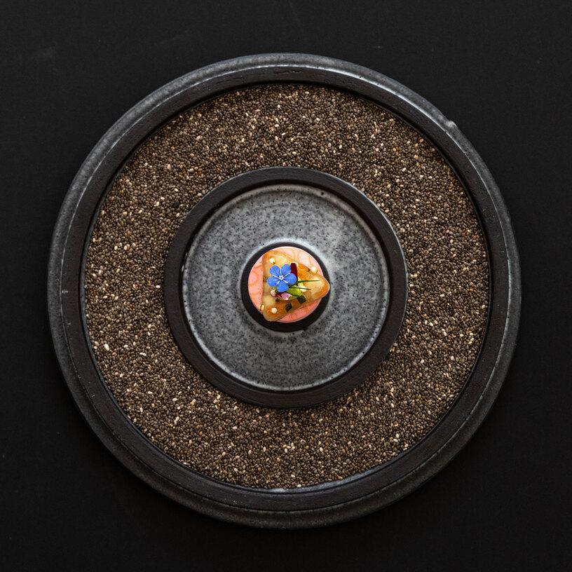 Gericht angerichtet auf schwarzem Teller Gericht angerichtet auf schwarzem Teller